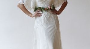 V-neck wedding dress with flutter sleeves and lace details by .